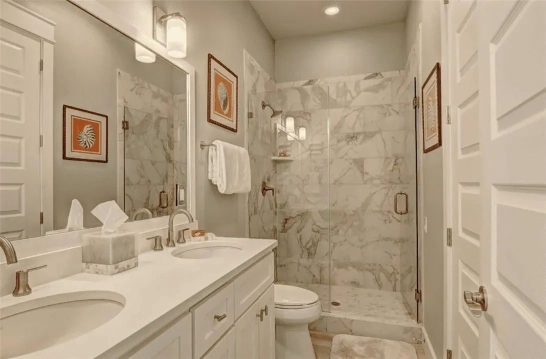 Devin Elder (DJE Texas) — Port Aransas beach house — Marble-tiled bathroom with double vanity 717 Sunrise Ave Port Aransas TX — beach house — Marble-tiled bathroom with double vanity