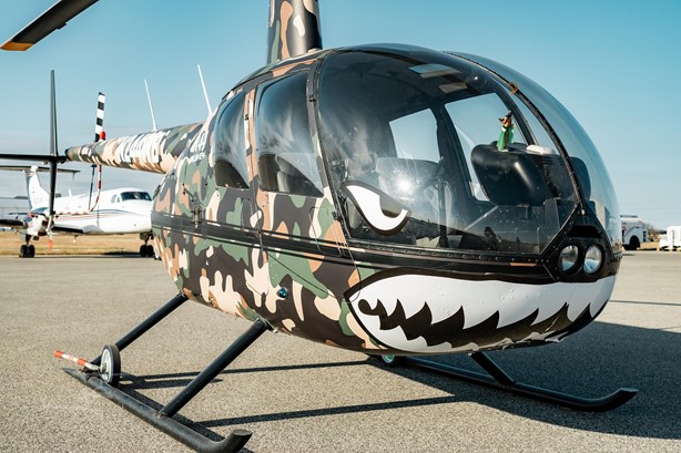 Devin Elder camo Robinson R44 helicopter N244WB — shark-mouth vinyl wrap — purchased with DJE Texas investor funds — wire fraud evidence